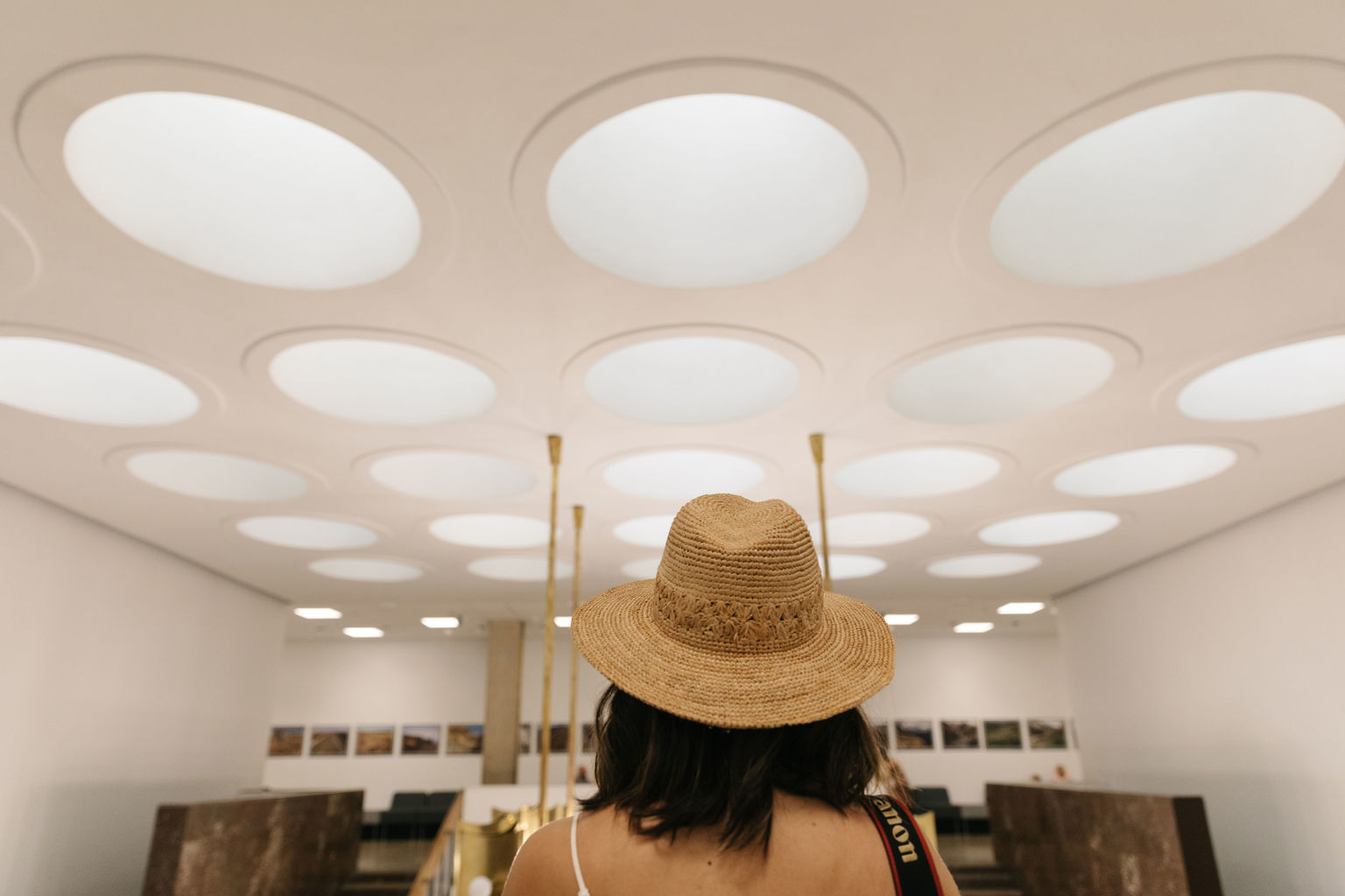 Foto realizzata all'interno di un palazzo che mostra una ragazza di spalle che indossa un cappello