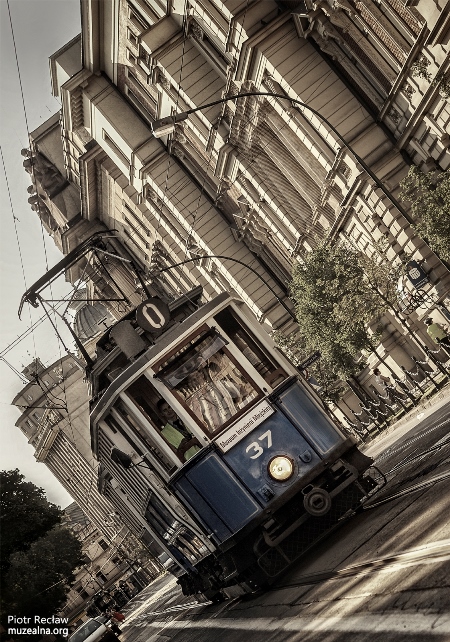 Imagen color sepia del tranvía nº 0 circulando por una calle monumental de Cracovia