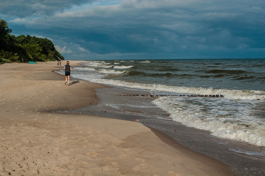 Playa de arena blanca con un escarpa al fondo en un día soleado