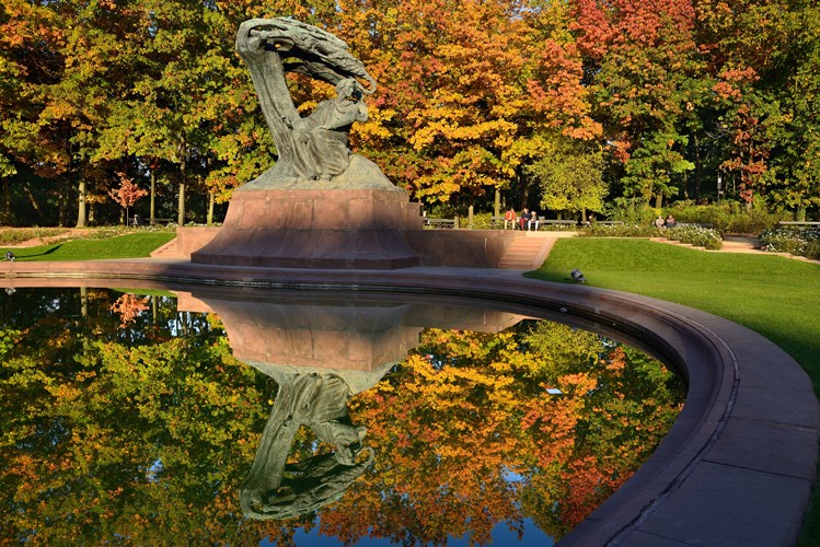 Monumento de Chopin rodeado de árboles del Parque Real de Lazienki, con un estanque al pie del monumento que representa al compositor sentado debajo de un sauce