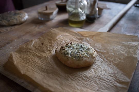 pan en forma de torta gruesa, con cebolla con especias en el medio, recién salida del horno