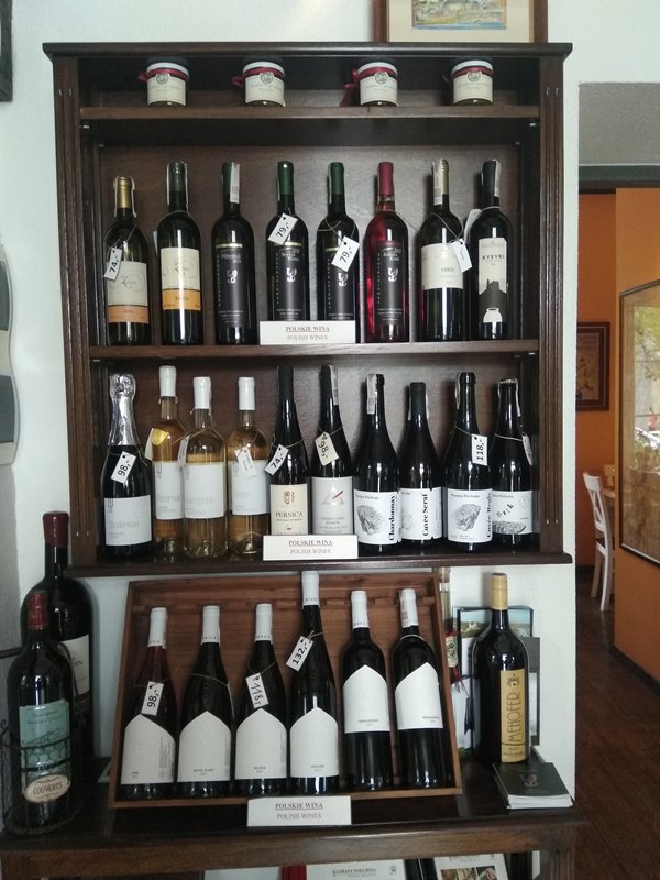 exposición de botellas de vino en una estantería de madera en un restaurante