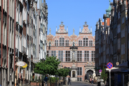 Calle con edificios burgueses a los dos lados y la fachada de otro edificio histórico en el fondo
