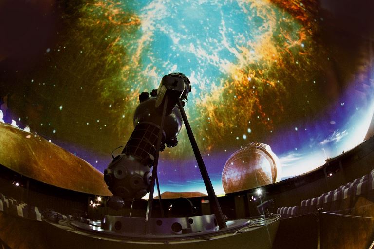 Parte del Planetario; en la cúpula cielo estrellado y en el centro del auditorio, un telescopio apuntando hacia el "cielo" 