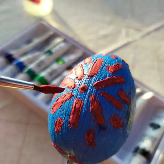 Tercer paso: motivos decorativos pintados sobre el huevo previamente pintado de azul como color de fondo