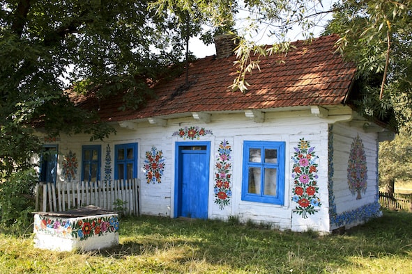 Casetta di legno dipinta a tema floreale, in campagna