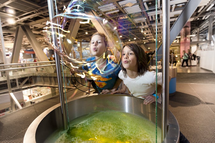 Foto di due bambini che giocano con le bolle di sapone all'interno del Centro scientifico di Copernico a Varsavia