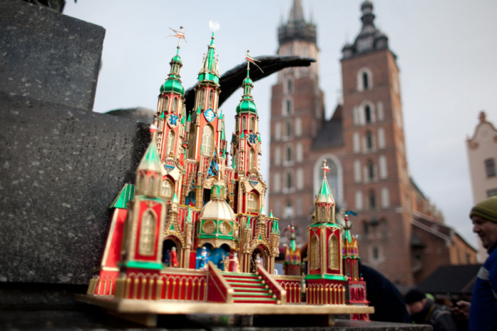 Foto di un presepe tipico; sullo sfondo, basilica di Cracovia