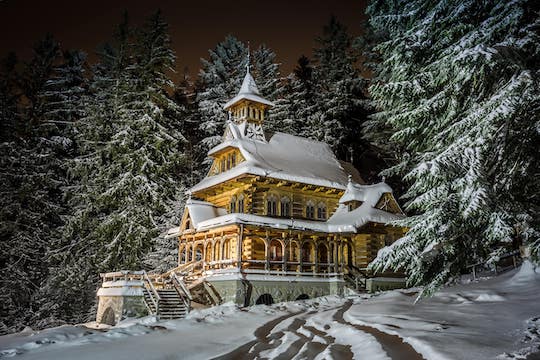 Casa in legno in mezzo al bosco, ricoperta di neve, esempio di architettura tipica di Zakopane