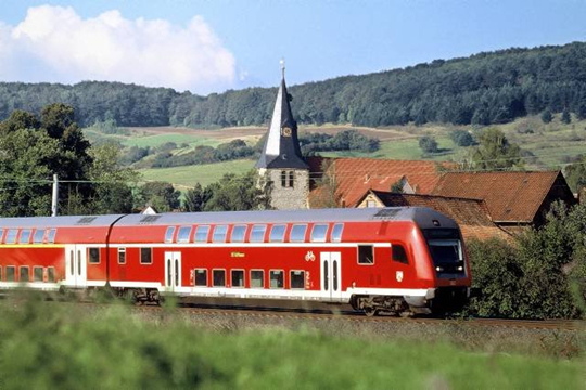 treno rosso in viaggio sui binari. Paesaggistica naturale.