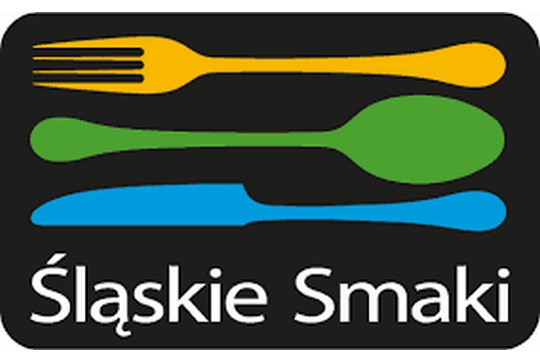 Logo di "Śląskie Smaki": sfondo nero con una forchetta gialla, un cucchiaio verde ed un coltello azzurro.