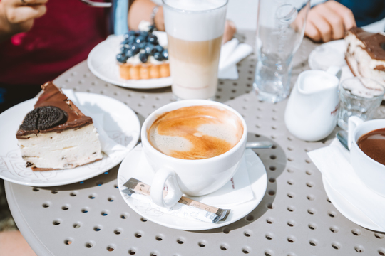 Foto che rappresenta un tavolo con il cappuccino e dei dolci