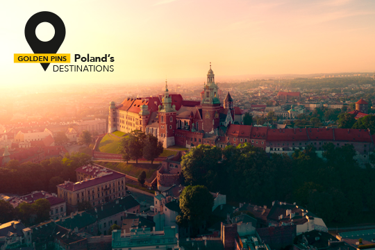 Foto panoramica realizzata dall'alto del castello reale di Wawel, a Cracovia, durante il tramonto. In alto scritta "Golden Pins Poland's Destinations".