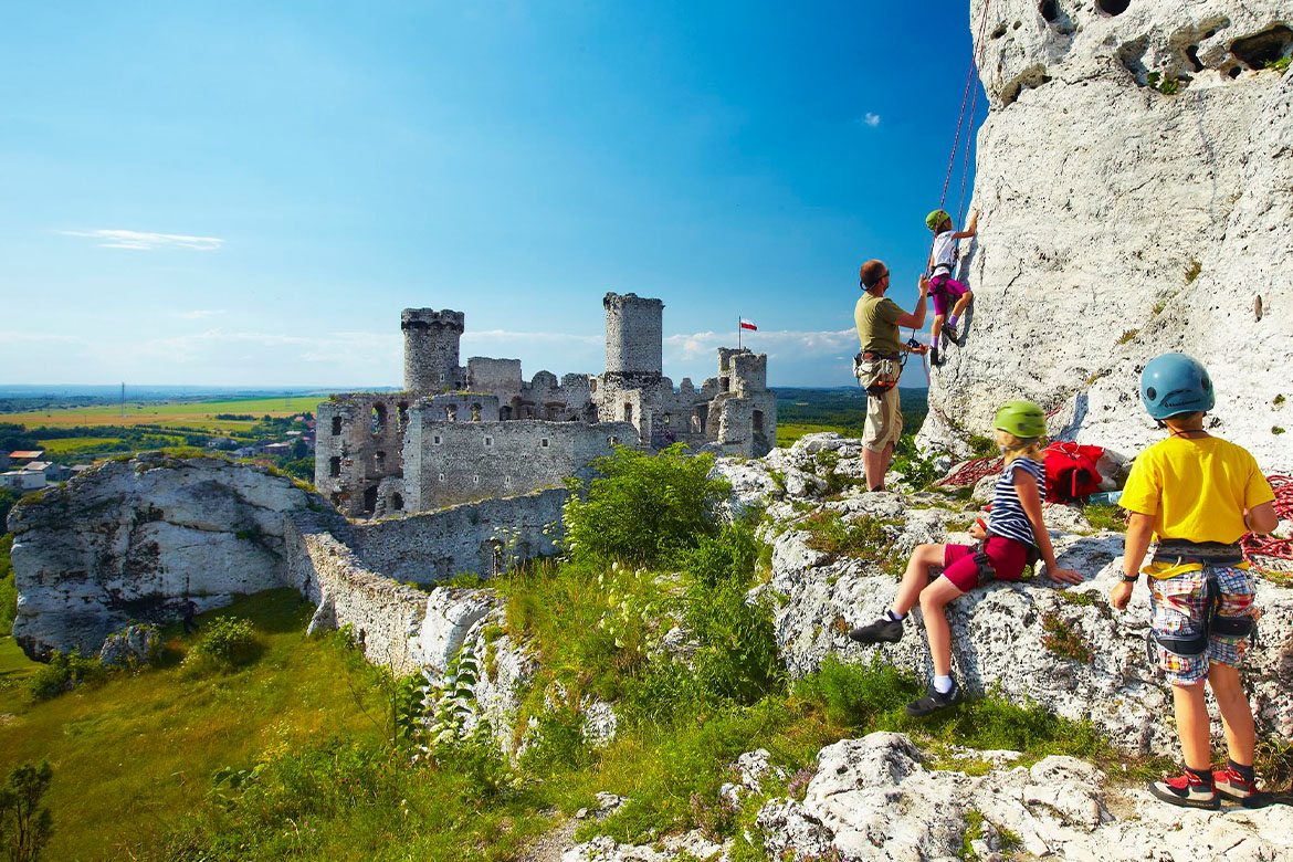 paisagem com rochas e ruínas de um castelo com alpinistas descansando